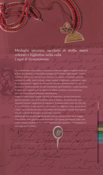 Medaglie spezzate, sacchetti di stoffa, nastri colorati e bigliettini nella culla